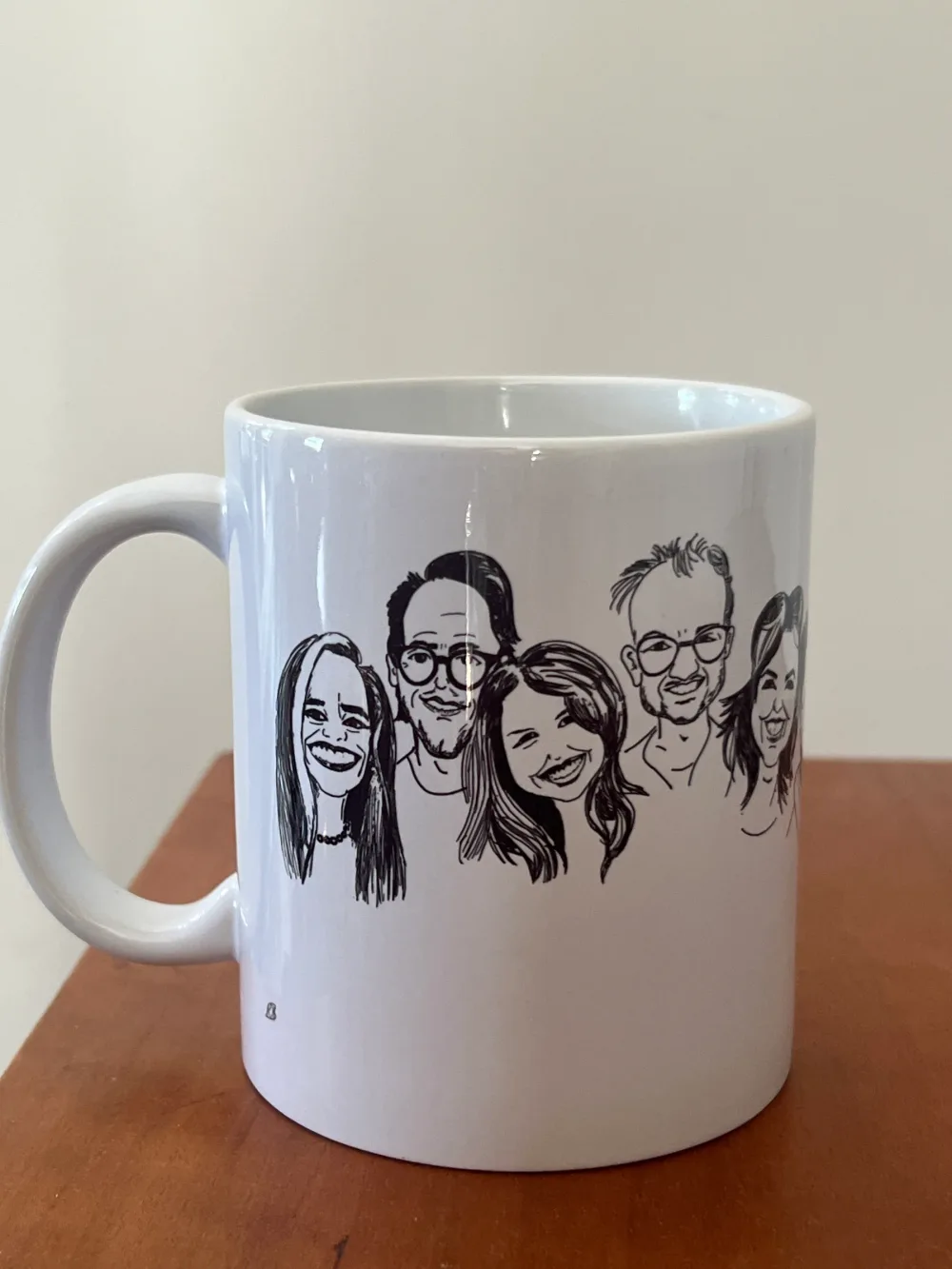 Witte mok met karikaturen van vijf familieleden in zwarte lijnen.