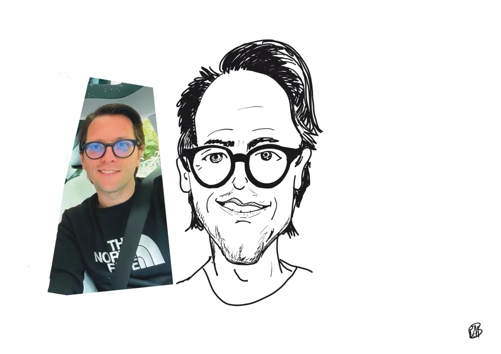 Karikatuur in lijnen van een man met bril, naast de foto waarnaar hij getekend is.