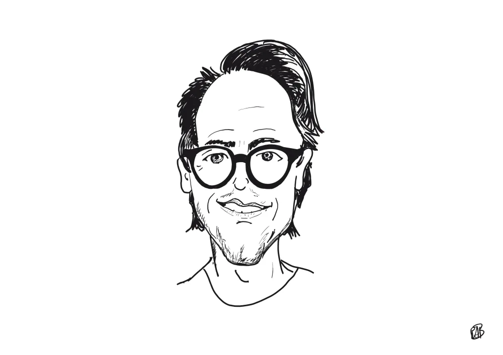 Lijntekening van een man met een ronde, donkere bril en een sikje.
